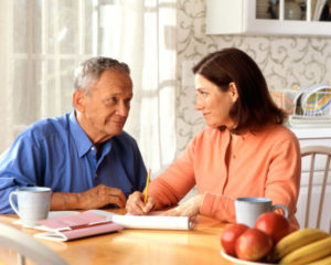 17068-a-woman-and-older-man-sitting-at-a-table-pv