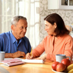 17068-a-woman-and-older-man-sitting-at-a-table-pv