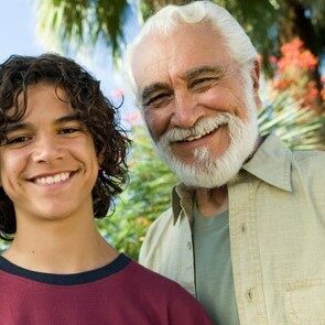 Boy (13-15) with Father and Grandfather outdoors, front view portrait.